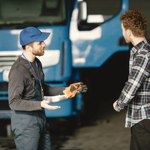 two-guys-talking-about-work-work-garage-near-truck-transfer-documents-with-goods
